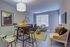 Modern living room with stylish decor, featuring a cozy seating area, chic wooden furniture, and vibrant wall art, perfect for relaxation and entertaining.