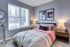 Cozy bedroom with a large window, elegant decor, and a comfortable bed with stylish bedding, offering a serene and inviting atmosphere.