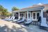 Inviting outdoor patio with sleek lounge chairs and charming french doors, perfect for relaxation and enjoying the sunny day.