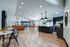 Modern open-concept living space with stylish seating, pool table, chic lighting, and sleek kitchen bar area.