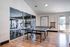 Modern recreational room with sleek ping pong table and gym equipment behind glass partition, ideal for active lifestyle enthusiasts.