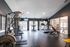 Modern fitness center featuring state-of-the-art exercise equipment, including treadmills, weight machines, and indoor cycling, with bright natural light.
