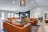 Elegant open-concept living space featuring stylish leather sofas, a chic pool table, modern lighting, and a sophisticated kitchen with black accents.