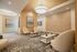 Elegant and modern lounge area with stylish decor, featuring cozy beige chairs, chic coffee tables, and artistic wall art.