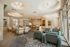 Elegant open-concept living room with modern furnishings, cozy armchairs, and abundant natural light streaming through large windows.