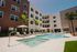 Luxurious apartment complex showcasing a stunning outdoor pool area with sun loungers, umbrellas, and modern architecture.