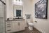 Modern bathroom with sleek vanity, elegant shower, and stylish wall art, offering a serene and sophisticated ambiance.