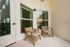 Charming apartment balcony featuring elegant wicker chairs and a serene atmosphere, perfect for relaxation.
