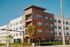 Modern apartment building with contemporary design, lush landscaping, and sunny outdoor spaces.