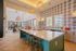 Bright and stylish kitchen and dining area with modern island seating, chic pendant lights, and a textured accent wall.