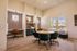 Bright and inviting home office space featuring stylish wallpaper, modern desk areas, chic lighting, and large windows with a view of sunny outdoor scenery.