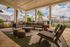 Luxurious outdoor living space with modern furniture, surrounded by lush greenery and palm trees, offering a serene pool view.
