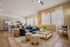 Inviting open-concept living room with modern kitchen, featuring a chic blue sofa and stylish decor accents.