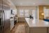 Elegant kitchen featuring a spacious island with sleek countertops, modern stainless steel appliances, and stylish cabinetry in an open-concept living area.