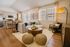 Chic living area featuring a modern open kitchen, elegant furniture, natural light, and stylish decor accents.