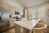 Modern kitchen with sleek stainless steel appliances, elegant cabinetry, and a spacious island with chic bar stools.