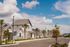 Charming suburban neighborhood with modern white houses, palm trees, and clear blue skies.