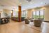 Elegant open living space with modern furniture, large windows, and a scenic view; features inviting seating, stylish dining area, and chic lighting.
