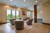 Bright and spacious living area with modern armchairs, large windows, and elegant decor, offering stunning outdoor views.