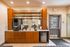 Inviting modern kitchenette with sleek wooden cabinetry, a compact coffee station, and ample counter space.