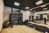 Modern gym with premium fitness equipment, including TRX, weights, punching bag, and mirrors on hardwood flooring for an invigorating workout experience.