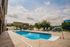 Inviting outdoor pool area with stylish lounge chairs and shaded seating, perfect for relaxation and recreation.