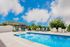 Inviting outdoor pool area with sun loungers and bright blue skies, perfect for relaxation and recreation.