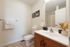 Elegant bathroom with modern fixtures, featuring a sleek vanity, large mirror, and tasteful decor accents.