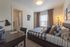 Inviting bedroom with cozy plaid bedding, warm lighting, and an efficient workspace, perfect for comfort and productivity.