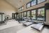 Modern fitness center with state-of-the-art gym equipment surrounded by large windows offering a bright and inviting atmosphere.