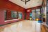 Chic home gym space with vibrant red walls, large mirror, and ample workout equipment, perfect for fitness enthusiasts.