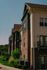 Charming red-brick apartment complex with green landscaping under a clear blue sky, offering modern living spaces and a serene environment.