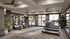 Modern gym with state-of-the-art cardio equipment, lush indoor plants, and bright natural lighting through large windows.