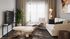 Sophisticated living room with modern decor, featuring a plush sofa, sleek armchair, large TV, and vibrant greenery accented by soft natural light.