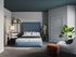Inviting bedroom with a cozy blue upholstered bed, modern decor, and vibrant greenery enhancing the tranquil ambience.