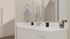 Modern bathroom vanity with sleek fixtures, elegant mirror, and stylish decorative towels.