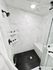 Contemporary shower with sleek marble tiles and hexagon black flooring.