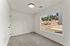 Bright, modern room with large window offering serene views of nature, perfect for relaxation and comfort.