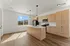 Bright modern kitchen featuring hardwood floors, sleek cabinetry, and a large window with mountain views.
