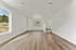 Bright living space with modern recessed lighting, large window with scenic views, and elegant wood flooring.