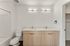 Modern bathroom with sleek dual sinks, chic lighting, and elegant wood cabinetry.