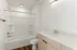 Sleek contemporary bathroom with elegant bathtub, modern vanity, and warm wood flooring.