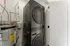 Modern laundry area featuring sleek stackable washer and dryer alongside energy-efficient water heater for maximum space-saving convenience.