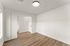 Bright and airy room with modern wood flooring and elegant white walls, perfect for a cozy living space.