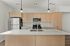 Modern kitchen featuring sleek wooden cabinetry, stainless steel appliances, and elegant pendant lighting above a spacious island.