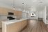 Modern kitchen with sleek cabinetry, stainless steel appliances, and spacious open floor plan with large window providing natural light.
