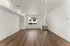 Bright and inviting living space with sleek hardwood floors, recessed lighting, and a modern window view.