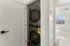 Modern apartment with in-unit stacked washer and dryer in a bright room with scenic mountain views.