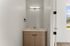Modern bathroom vanity with sleek lighting and stylish wooden cabinetry, offering a refreshing minimalistic design.