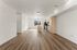 Contemporary open-plan kitchen and living area with sleek wood flooring, modern stainless steel appliances, and ample natural light.